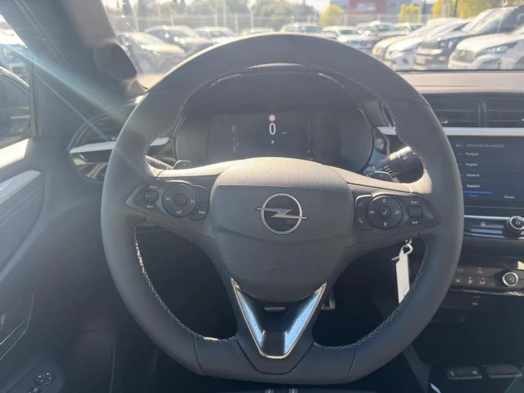 Vue frontale du volant noir de l’Opel Corsa 2025 avec commandes intégrées et tableau de bord digital.