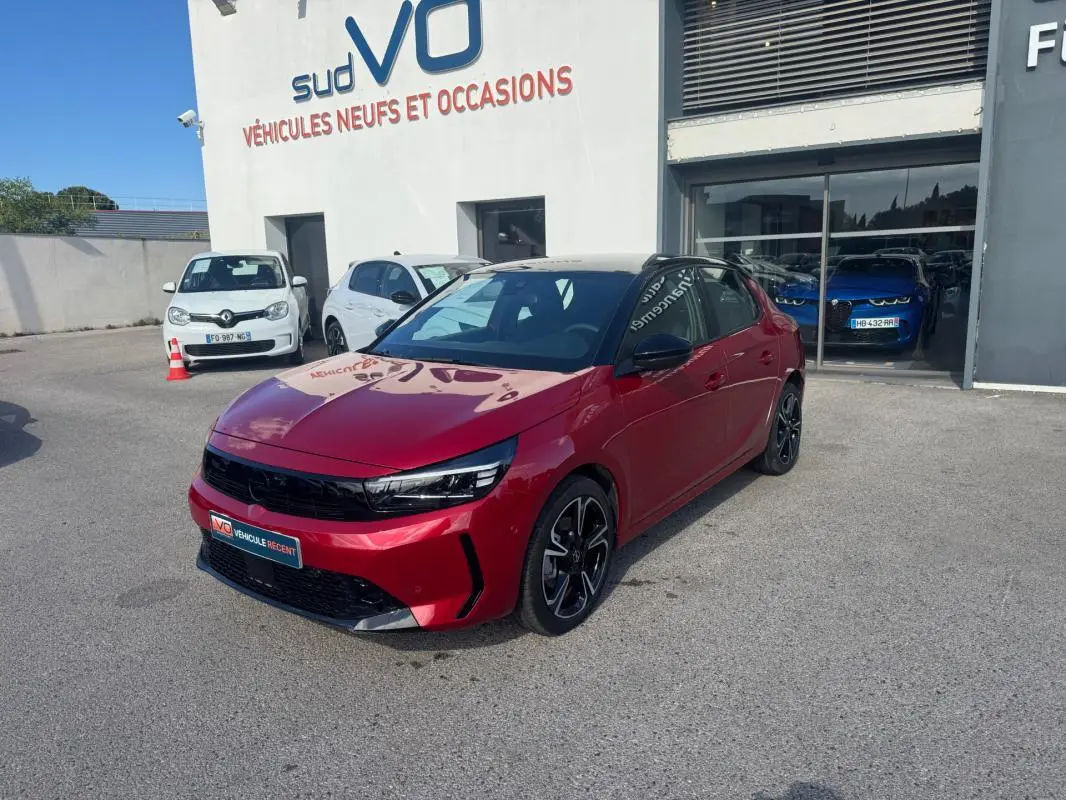 Opel Corsa rouge vue 3/4 avant droit, jantes alliage noires, toit noir et calandre noire brillante.