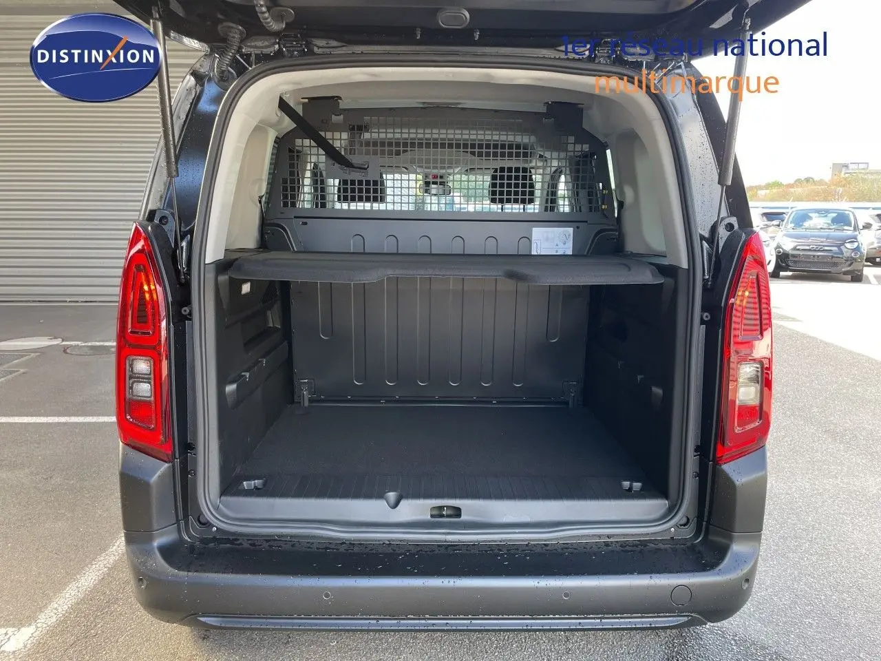 Vue arrière ouverte du Citroën Berlingo noir Perla Nera montrant l'espace de chargement avec séparation métallique.