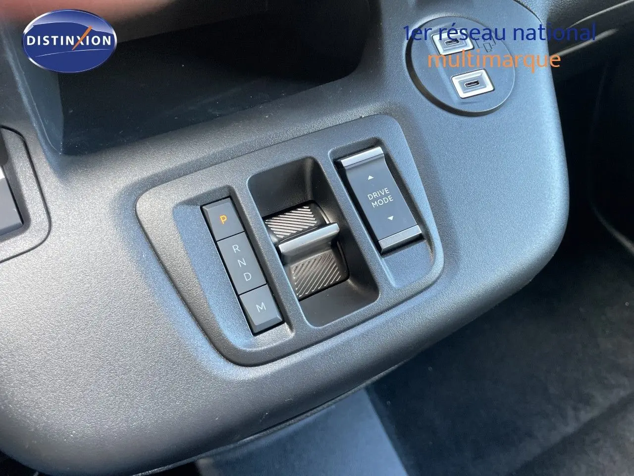 Gros plan sur la console centrale du Citroën Berlingo noir, montrant la commande de boîte automatique et le bouton Drive Mode.