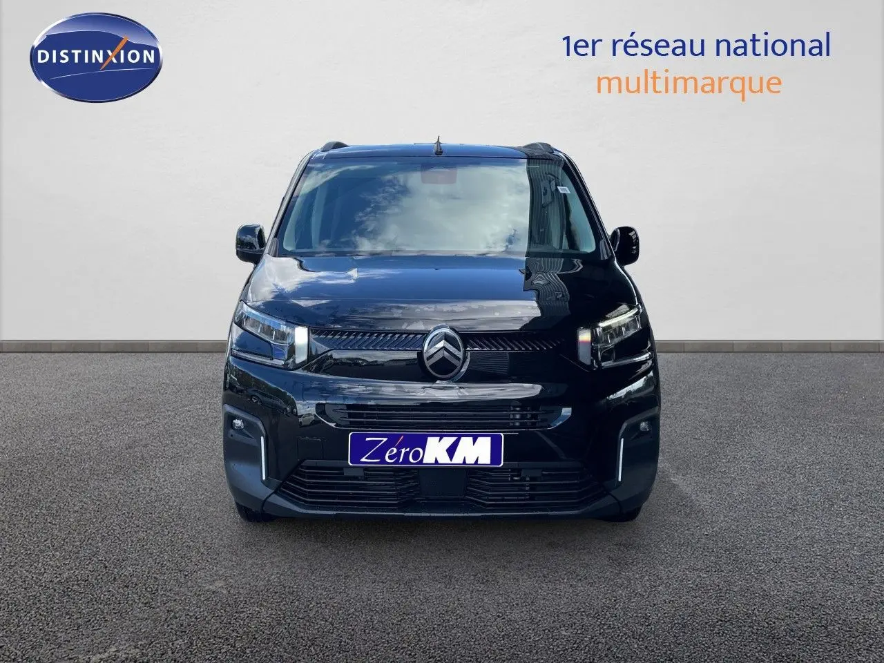Vue avant d'un Citroën Berlingo noir Perla Nera métal avec calandre moderne et phares LED allumés.