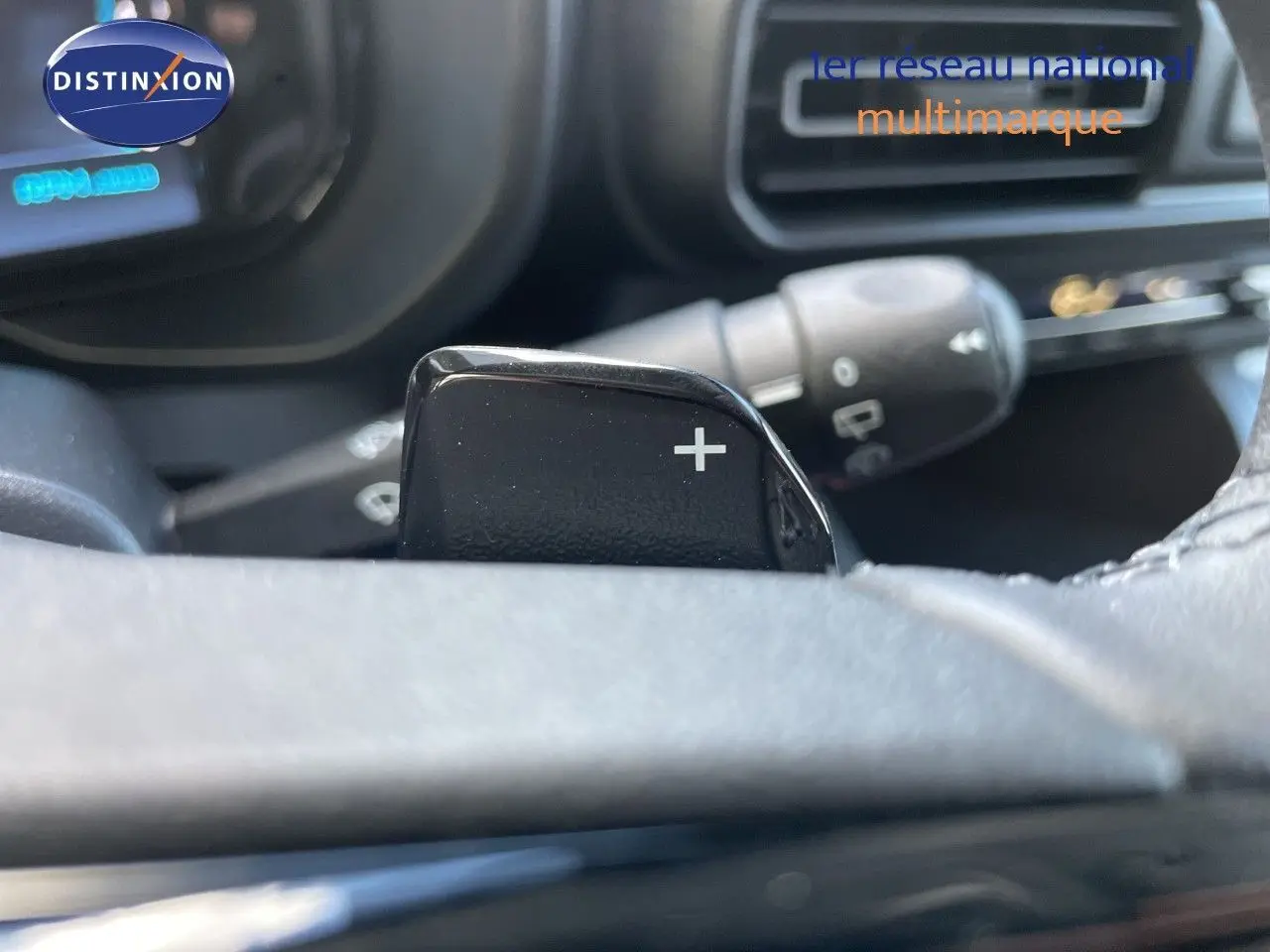Gros plan sur la palette de passage de vitesses "+" côté droit du volant dans l'habitacle d'un Citroën Berlingo noir.
