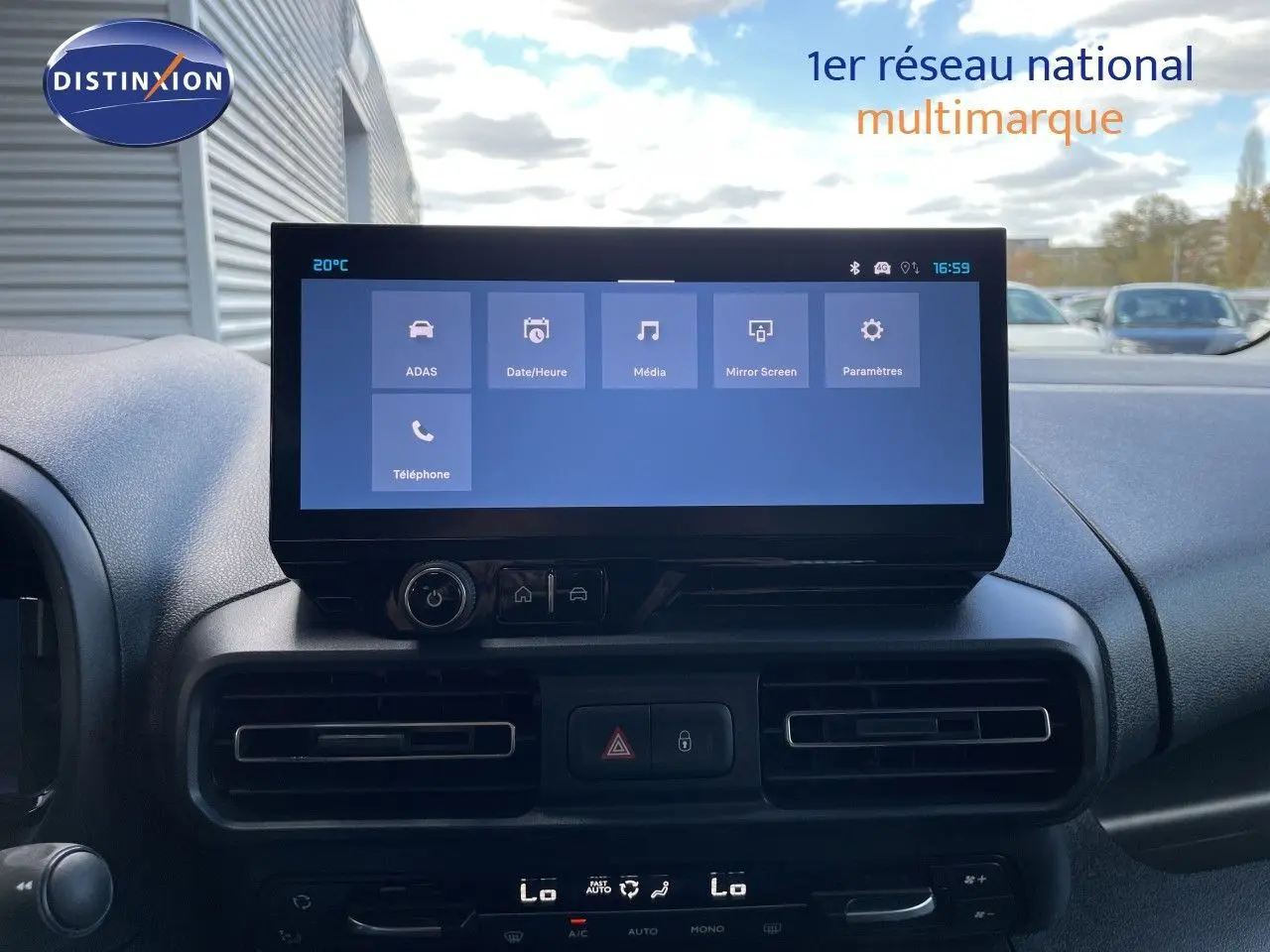 Vue intérieure centrée sur l'écran tactile du tableau de bord du Citroën Berlingo noir Perla Nera, avec commandes climatisation visibles.