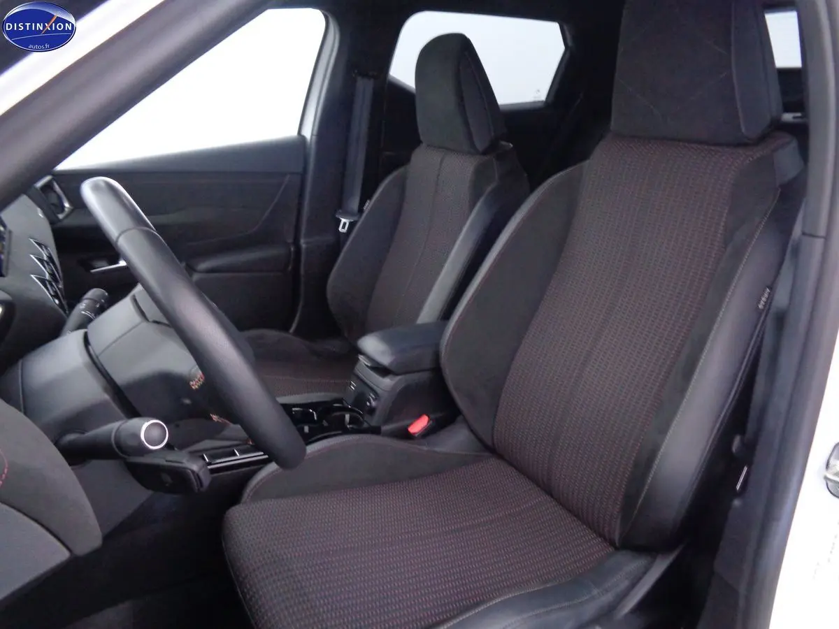 Vue intérieure côté gauche du DS3 Crossback blanc banquise, mettant en valeur les sièges avant en tissu noir avec surpiqûres rouges.