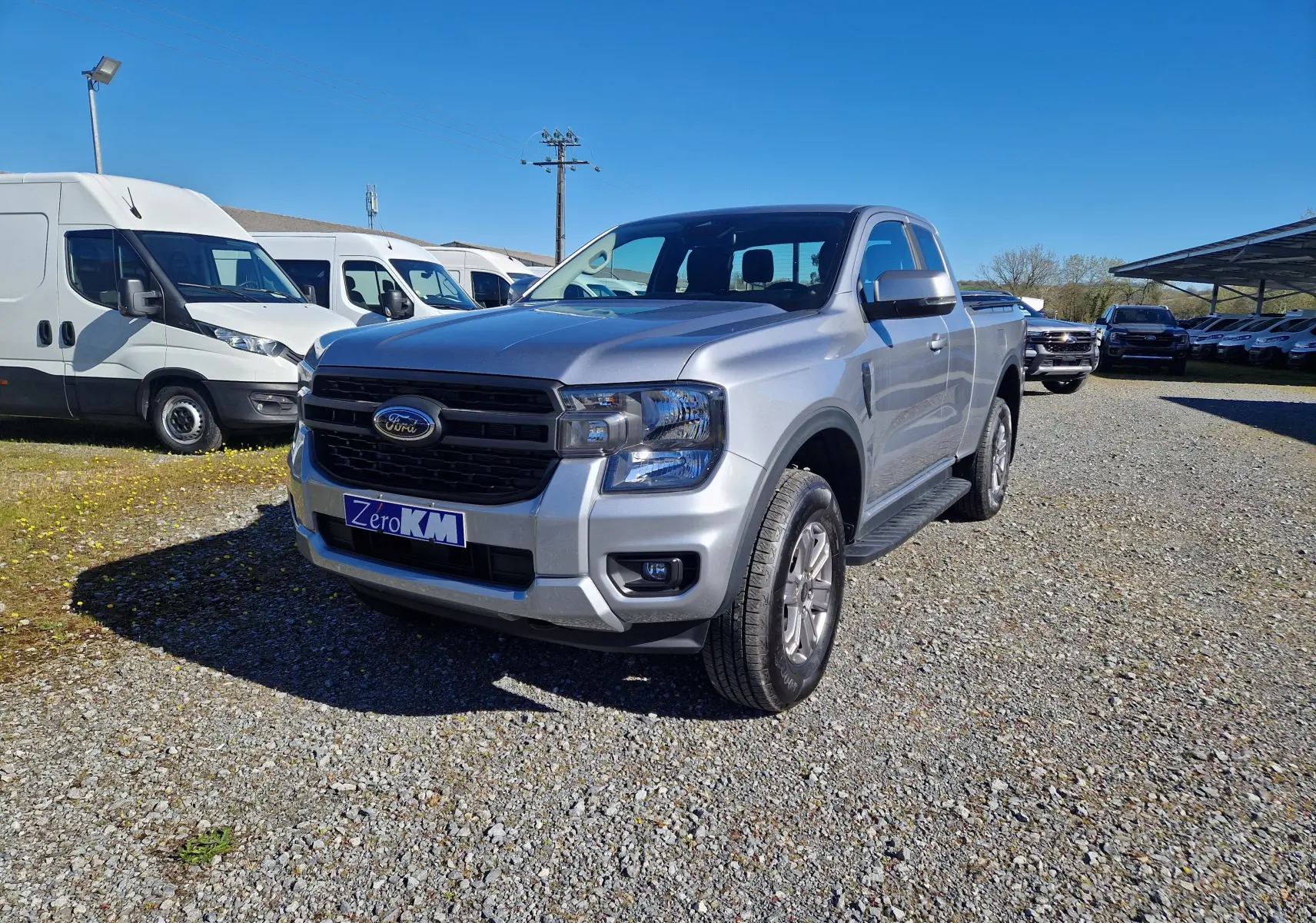 Vue 3/4 avant droite d'un Ford Ranger Super Cabine gris Iconic avec calandre noire et jantes alliage.