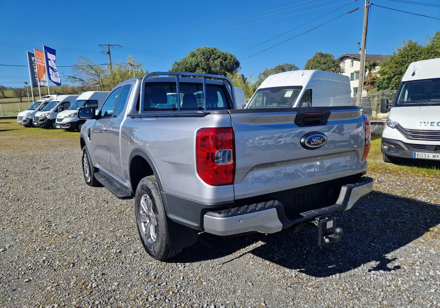 Vue 3/4 arrière droite du Ford Ranger Super Cabine gris Iconic avec attelage et barres de protection sur benne.