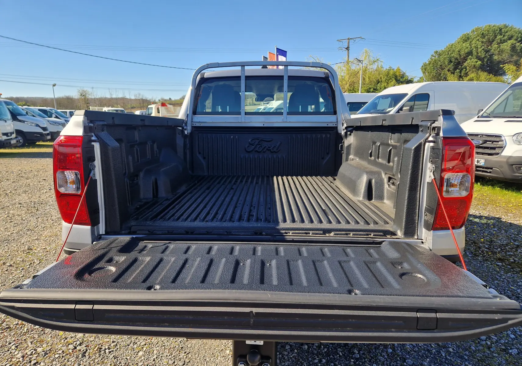Vue arrière du Ford Ranger Super Cabine gris Iconic 2026 avec benne ouverte et revêtement antidérapant noir.