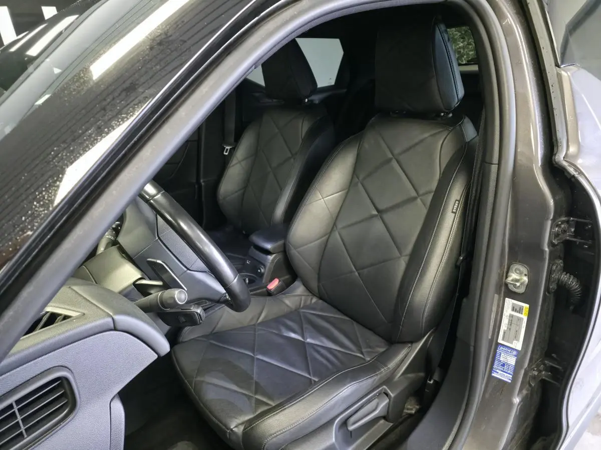 Vue intérieure côté conducteur du DS3 Crossback gris, mettant en valeur les sièges en cuir noir grainé et le volant cuir.