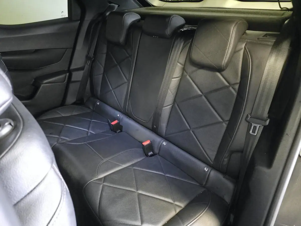 Vue intérieure de la banquette arrière en cuir noir grainé du DS3 Crossback 2022, avec appuie-têtes et ceintures visibles.