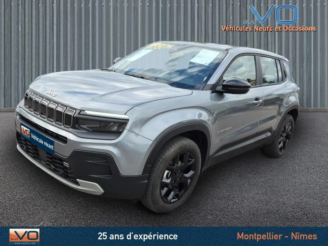 Jeep Avenger gris foncé vu en 3/4 avant droit, mettant en valeur sa calandre distinctive et ses jantes noires.