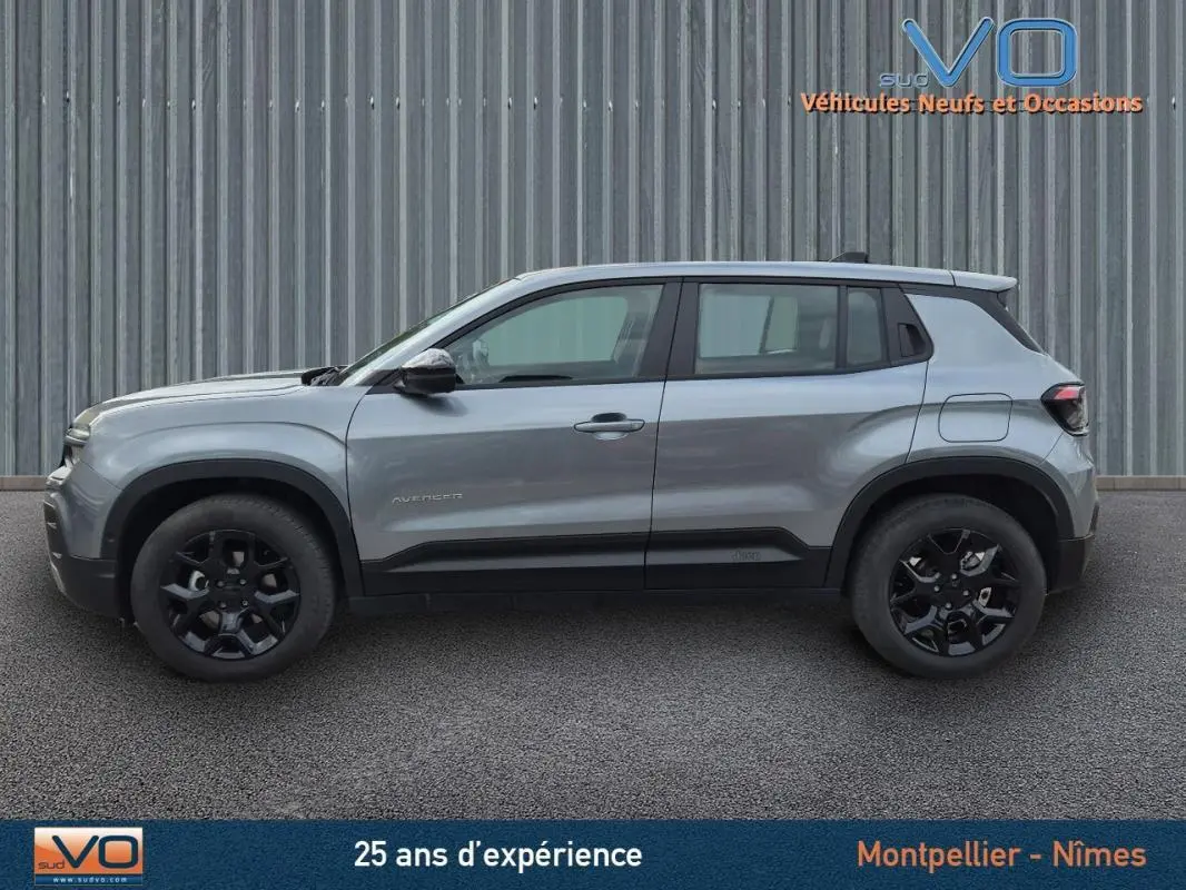 Profil côté gauche d'un Jeep Avenger gris foncé 2024 avec jantes noires et lignes modernes visibles.