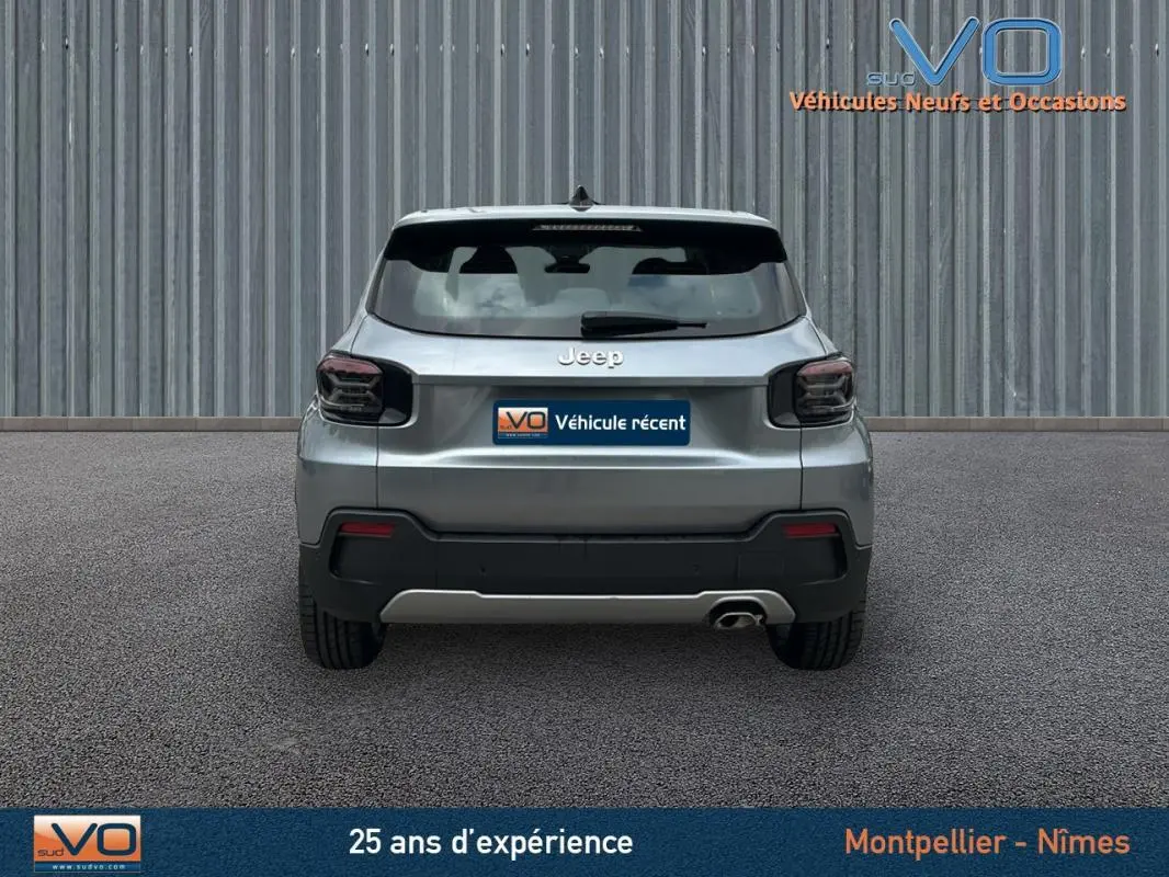 Vue arrière d'un Jeep Avenger gris foncé 2024 avec feux arrière fumés et une sortie d'échappement visible côté droit.