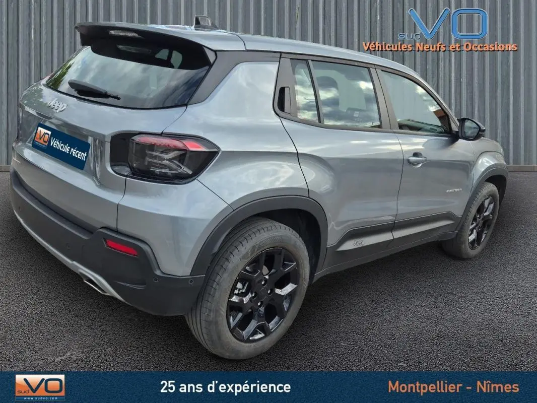 Jeep Avenger gris foncé vu en 3/4 arrière côté droit, avec jantes noires et feux arrière fumés.