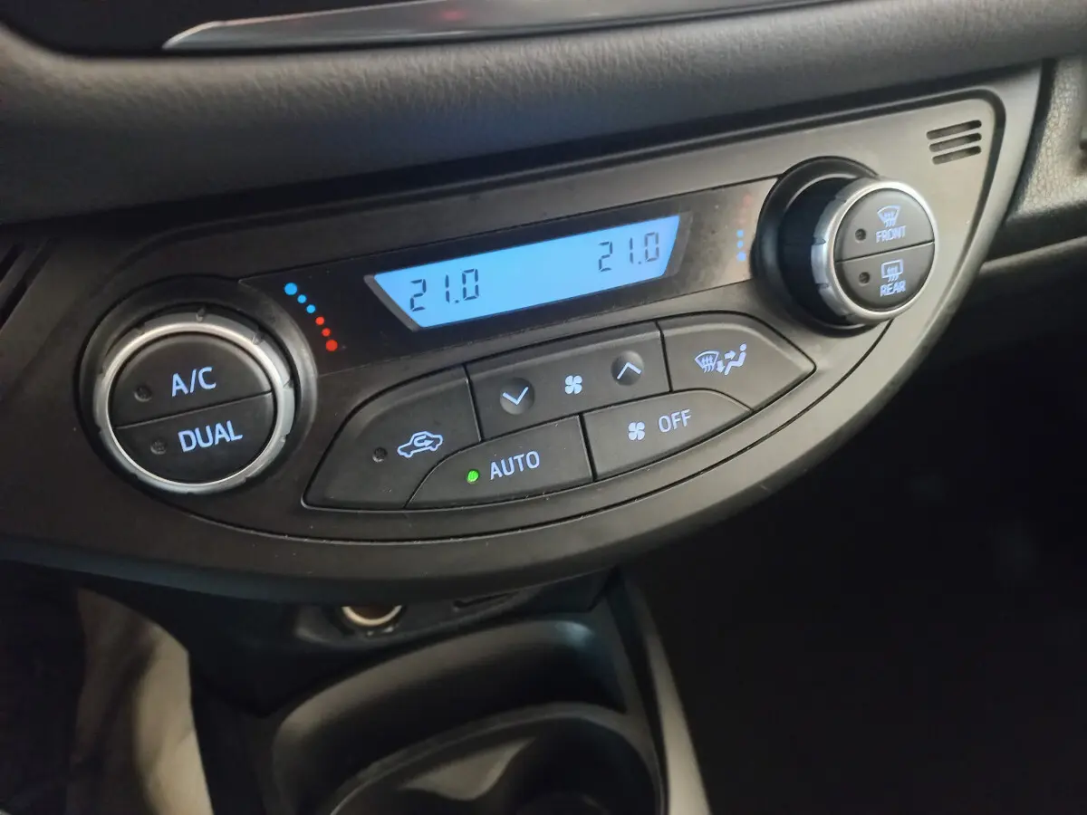 Vue rapprochée de la commande de climatisation bi-zone avec affichage digital dans une Toyota Yaris noire 2018.