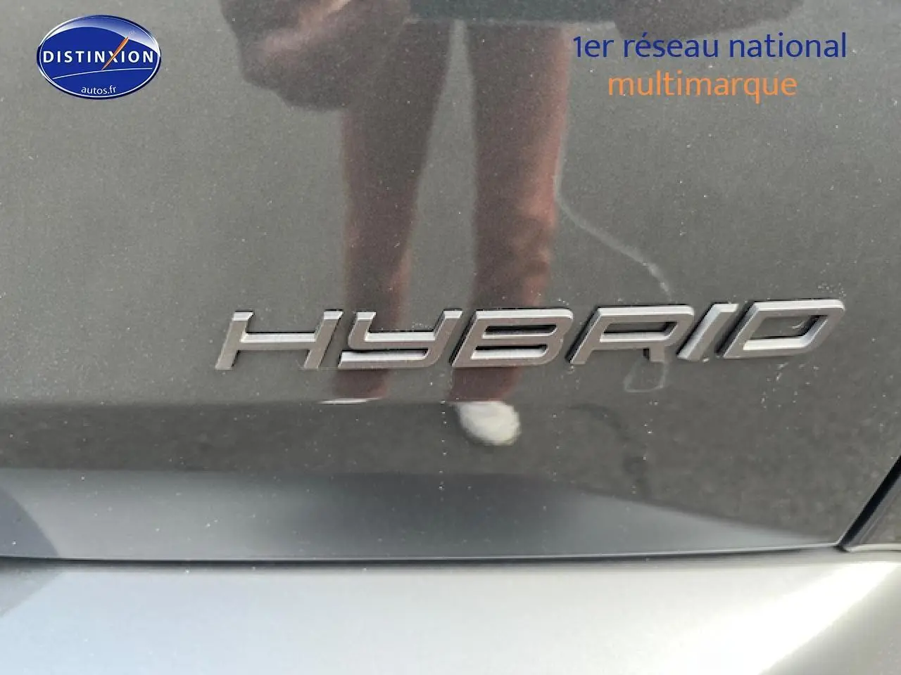 Gros plan sur l’inscription "Hybrid" en chrome sur la carrosserie gris titane d’un Peugeot 3008 2025.