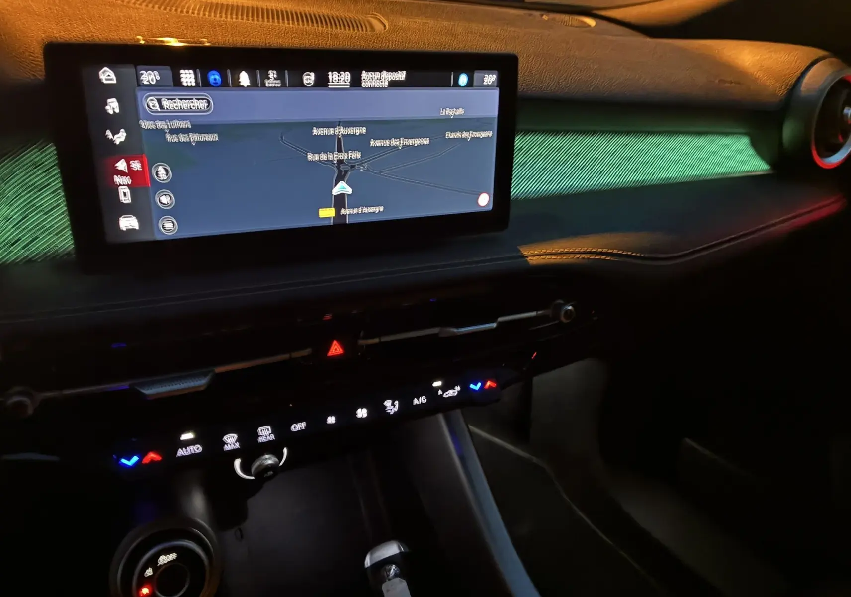 Vue intérieure du tableau de bord de l'Alfa Romeo Tonale 1.3 PHEV 280 BVA TI 2023 avec écran tactile et éclairage d'ambiance vert.