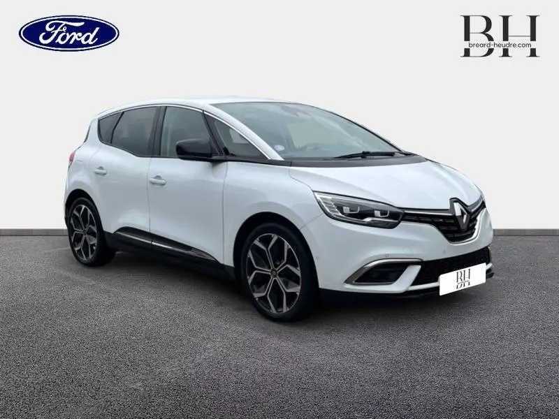 Renault Scénic blanc nacré en vue 3/4 avant droit, avec jantes alliage et détails noirs contrastants.