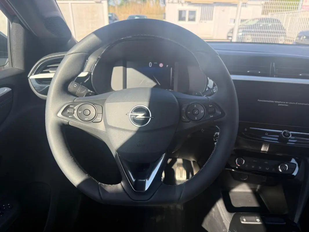 Vue intérieure centrée sur le volant noir de l'Opel Corsa 2025 avec commandes intégrées et tableau de bord numérique.