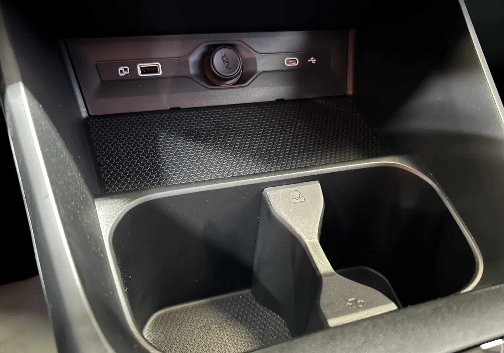 Gros plan intérieur sur la console centrale noire du MG3 1.5 Hybrid+ 195 Luxury avec prises USB et allume-cigare.