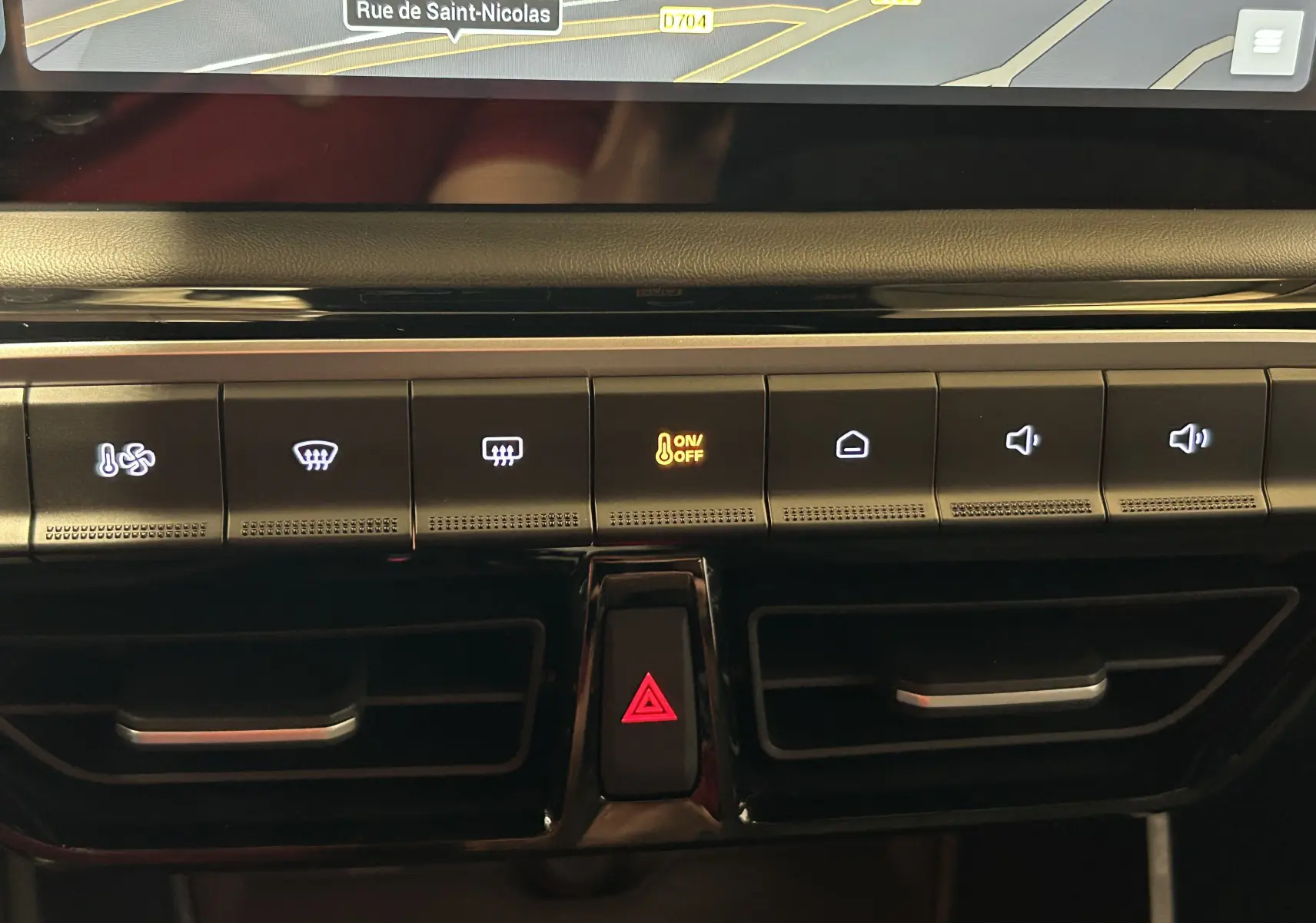 Vue rapprochée de la console centrale du MG3 Cosmic Silver 2026, avec boutons de climatisation et alerte hazard éclairée.