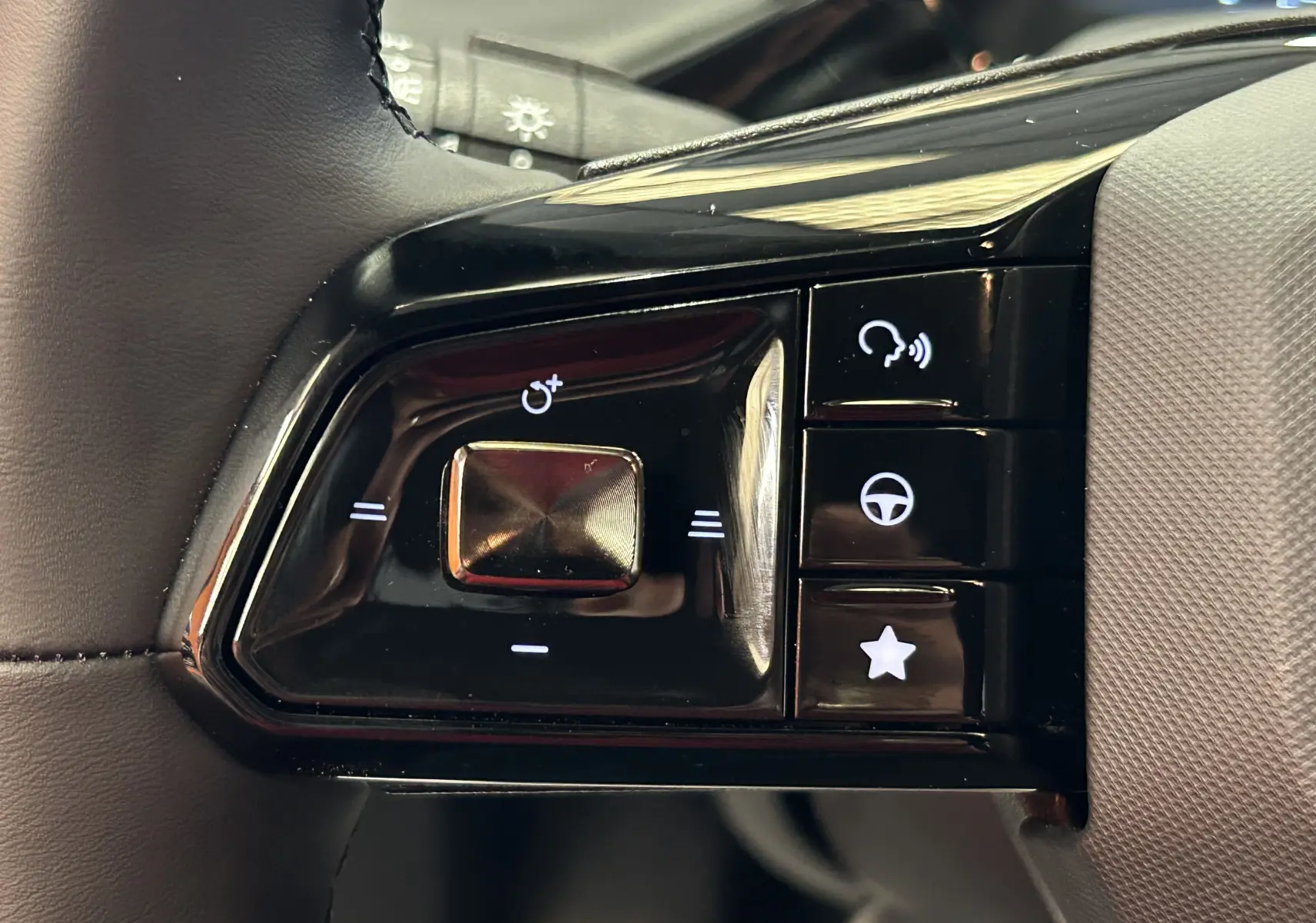 Gros plan sur les commandes de volant noir brillant du MG3 Cosmic Silver 2026, avec boutons multifonctions rétroéclairés blancs.