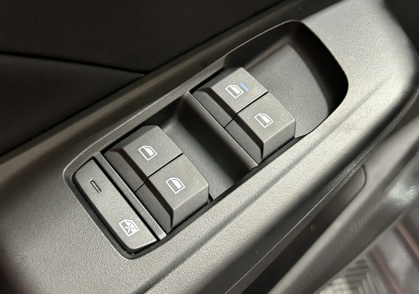 Gros plan sur les commandes des vitres électriques côté conducteur de la MG3 Cosmic Silver, finition intérieure noire.