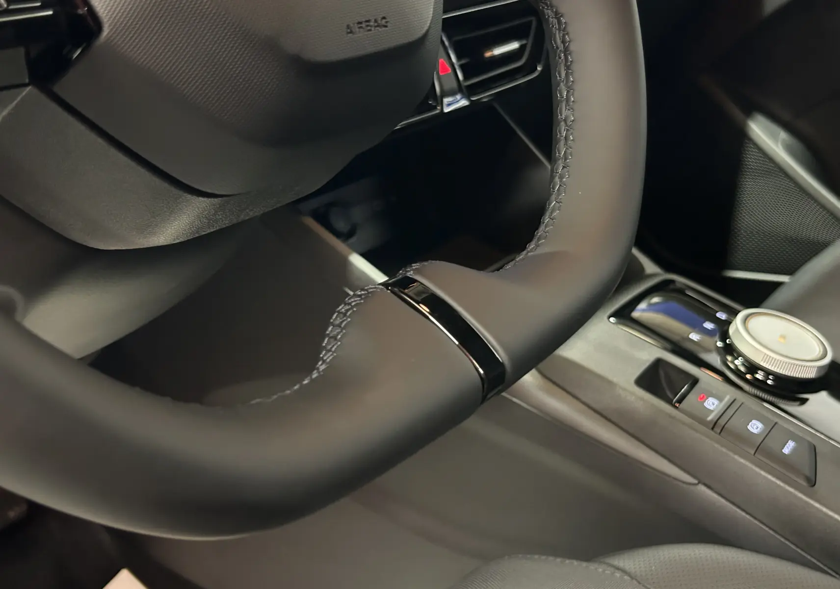 Gros plan sur le volant et la console centrale noire du MG3 1.5 Hybrid+ 195 LUXURY, intérieur moderne et soigné.