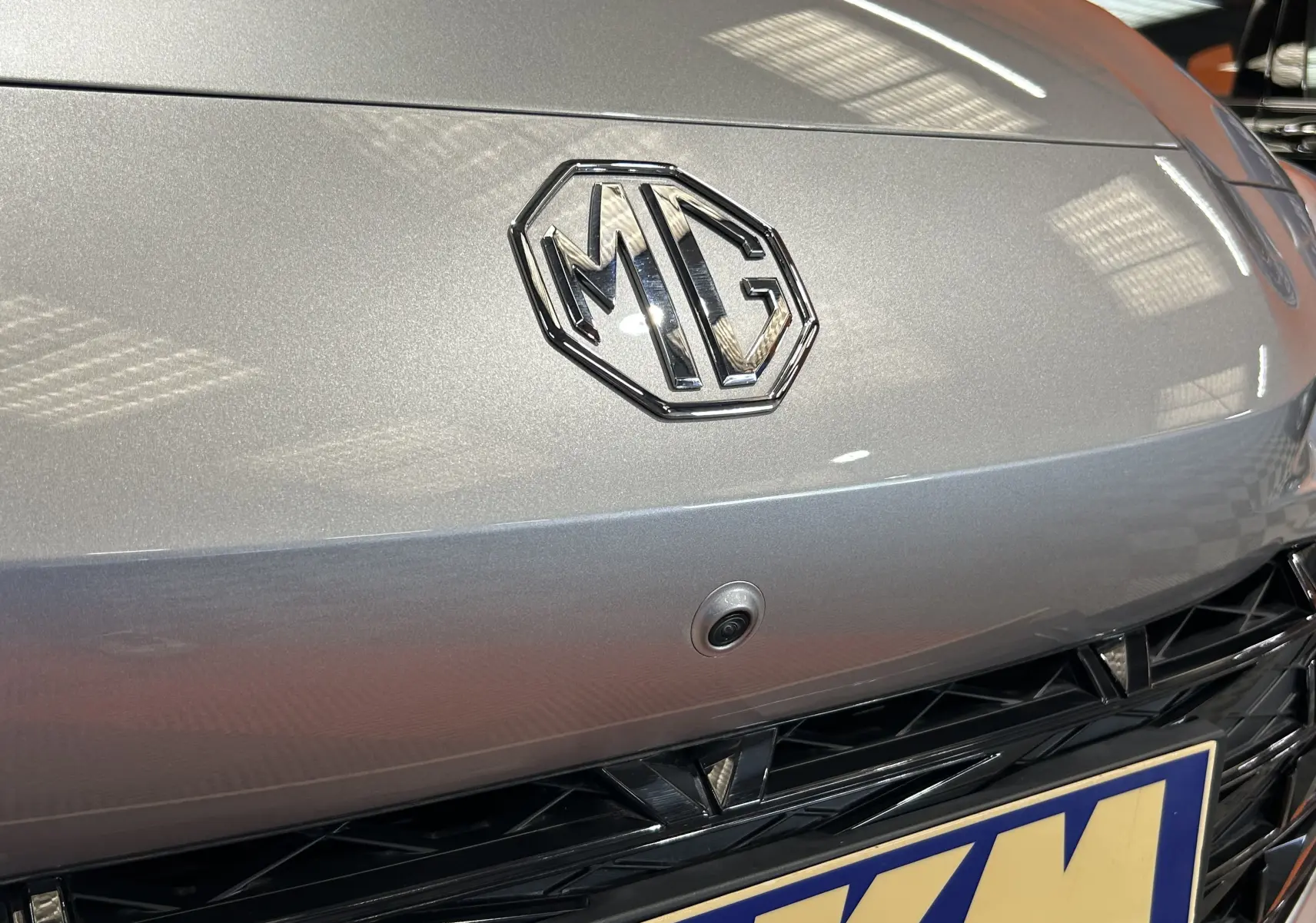 Gros plan sur l'avant Cosmic Silver du MG3 1.5 Hybrid+ avec logo MG et caméra 360° intégrée au-dessus de la calandre.