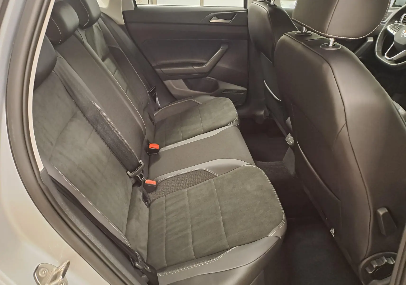 Vue intérieure côté gauche des sièges arrière en tissu noir et gris d'une Volkswagen Polo 2025 reflet d'argent.
