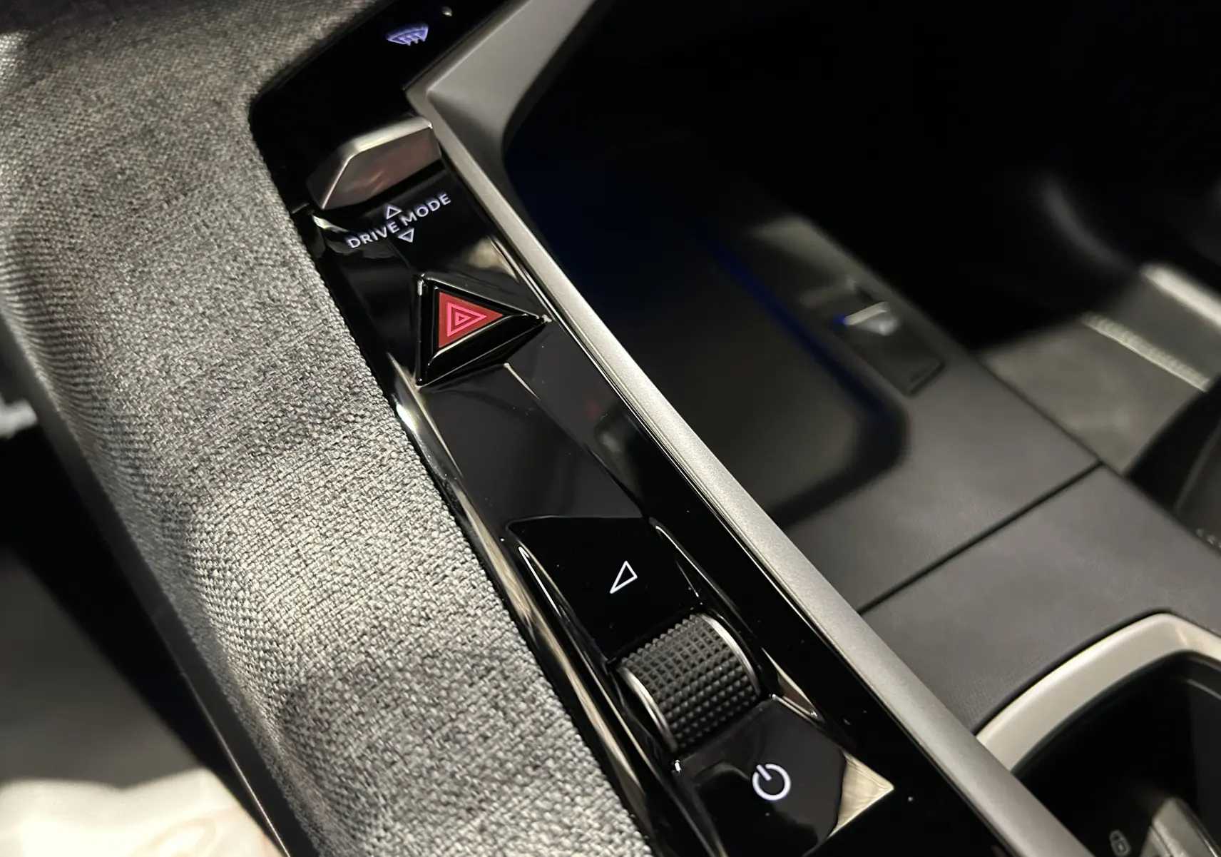 Détail de la console centrale du Peugeot 5008 Hybrid gris titane, avec boutons Drive Mode et alerte triangle rouge.