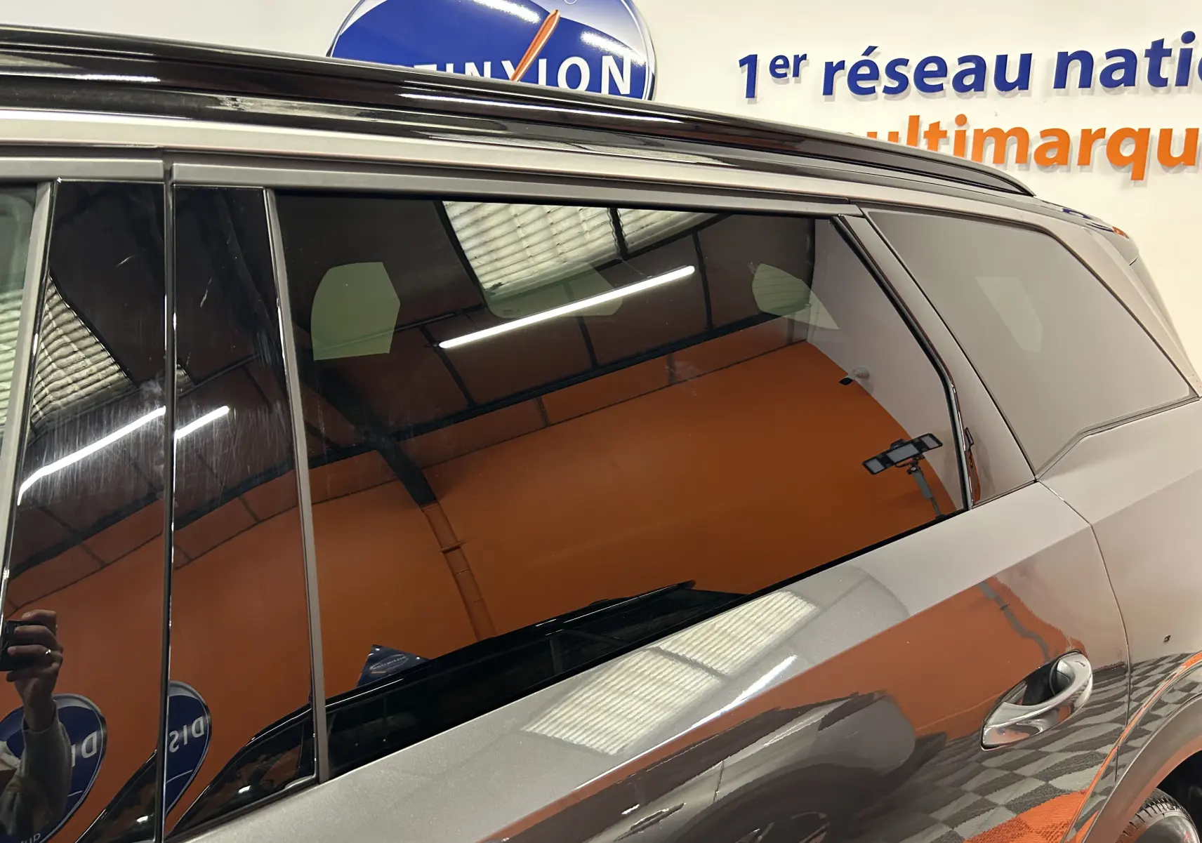 Vue latérale droite du Peugeot 5008 Hybrid gris titane, mettant en valeur les vitres teintées et la poignée de porte chrome.