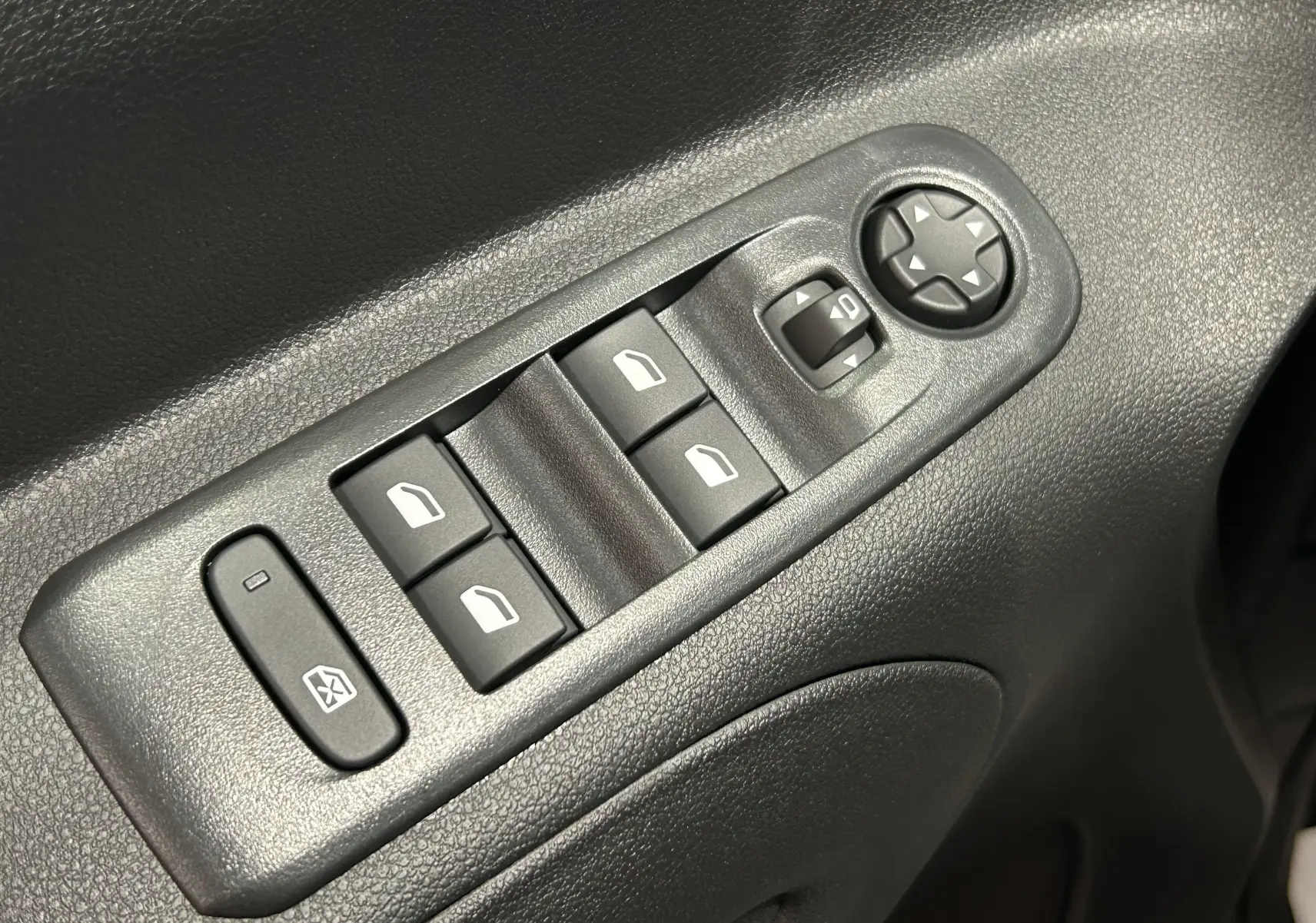 Gros plan sur les commandes de lève-vitres et réglage des rétroviseurs côté conducteur du Citroën Berlingo Multispace 2026.