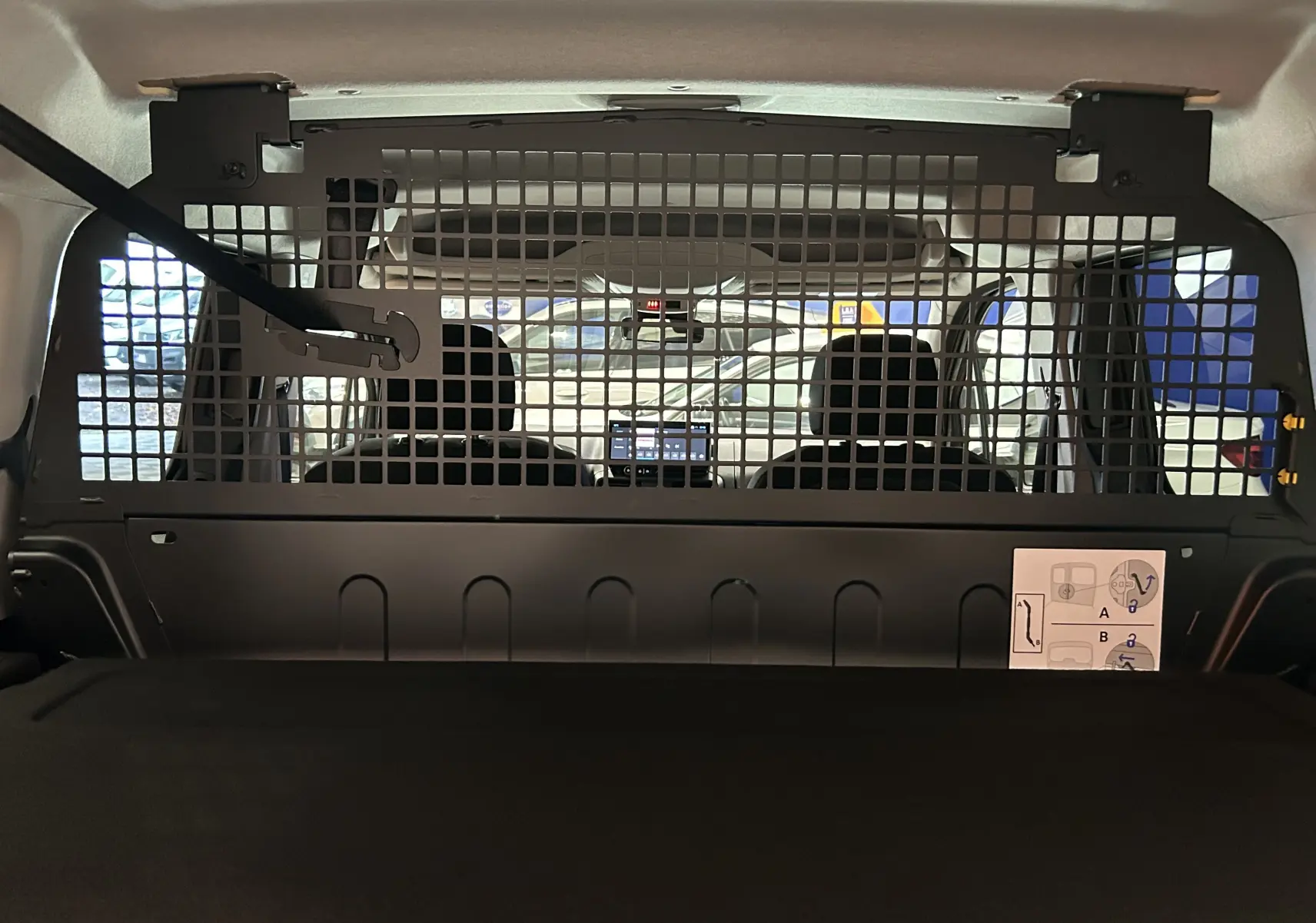 Vue intérieure arrière du Citroën Berlingo Multispace 2026 avec cloison grillagée de séparation et sièges avant visibles.