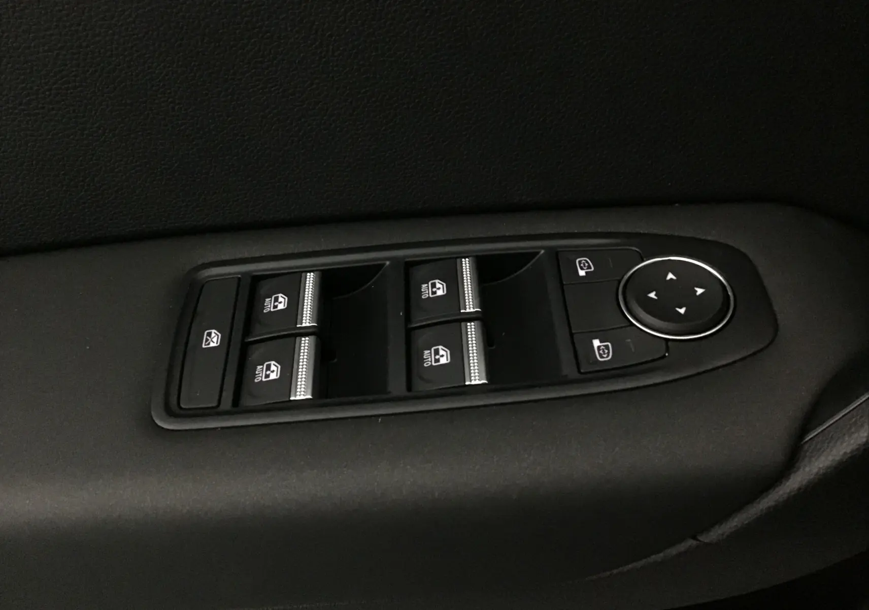 Panneau de commandes des vitres électriques et rétroviseurs sur la portière côté conducteur d'un Renault Captur noir/gris perle 2025.