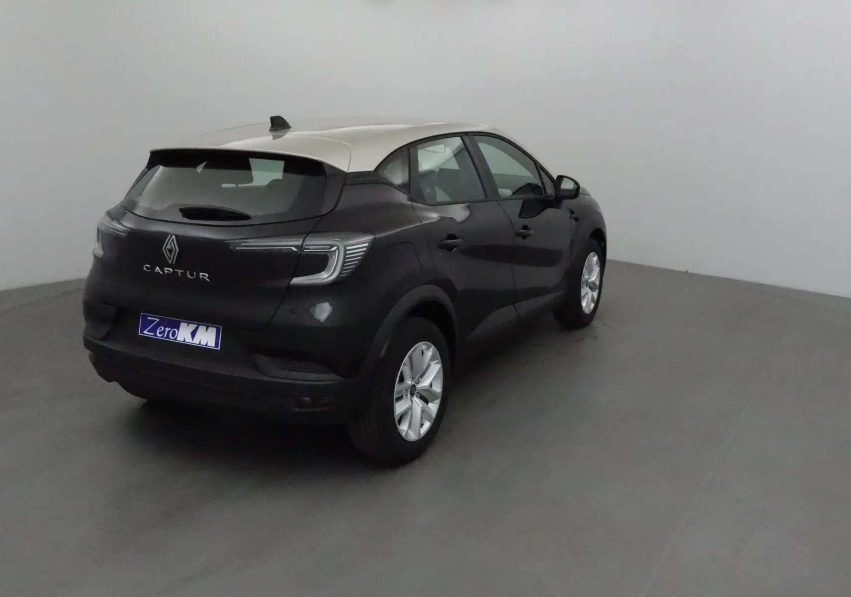 Vue 3/4 arrière droite du Renault Captur 2025 noir avec toit gris perle, feux LED et jantes argentées.
