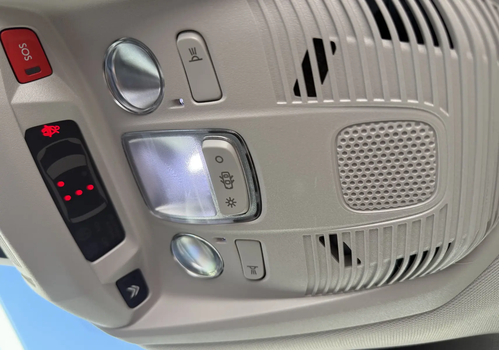 Plafonnier intérieur gris clair du Citroën C5 Aircross 2024 avec commandes d'éclairage et bouton SOS rouge.