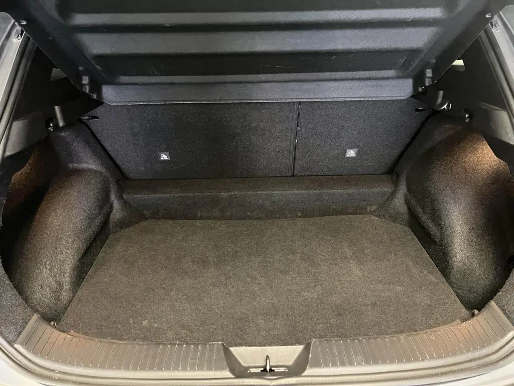 Coffre ouvert du Nissan Qashqai 1.3 Mild Hybrid 2023, vue intérieure spacieuse avec revêtement noir.