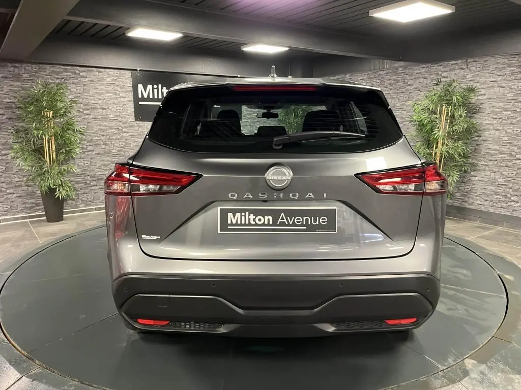 Vue arrière d'un Nissan Qashqai gris métallisé 2023 avec feux arrière LED et logo central visible.