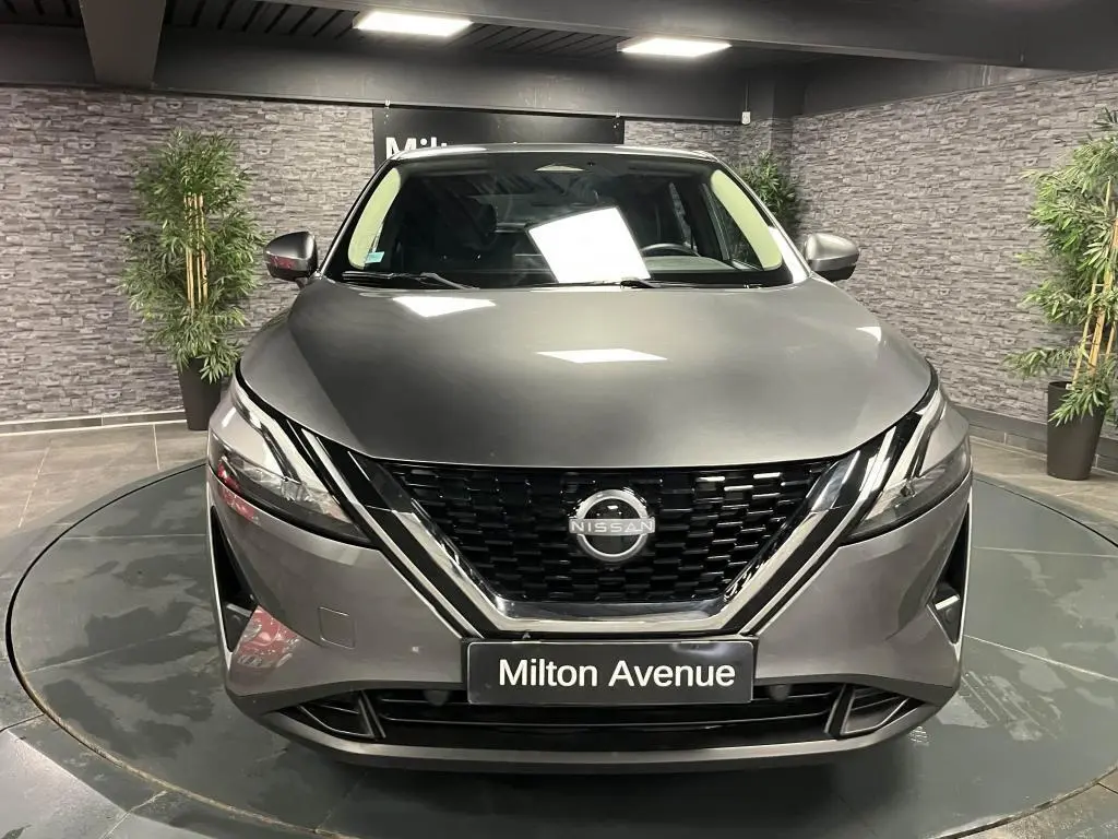 Vue frontale d'un Nissan Qashqai gris métallisé avec calandre noire et logo Nissan bien visible
