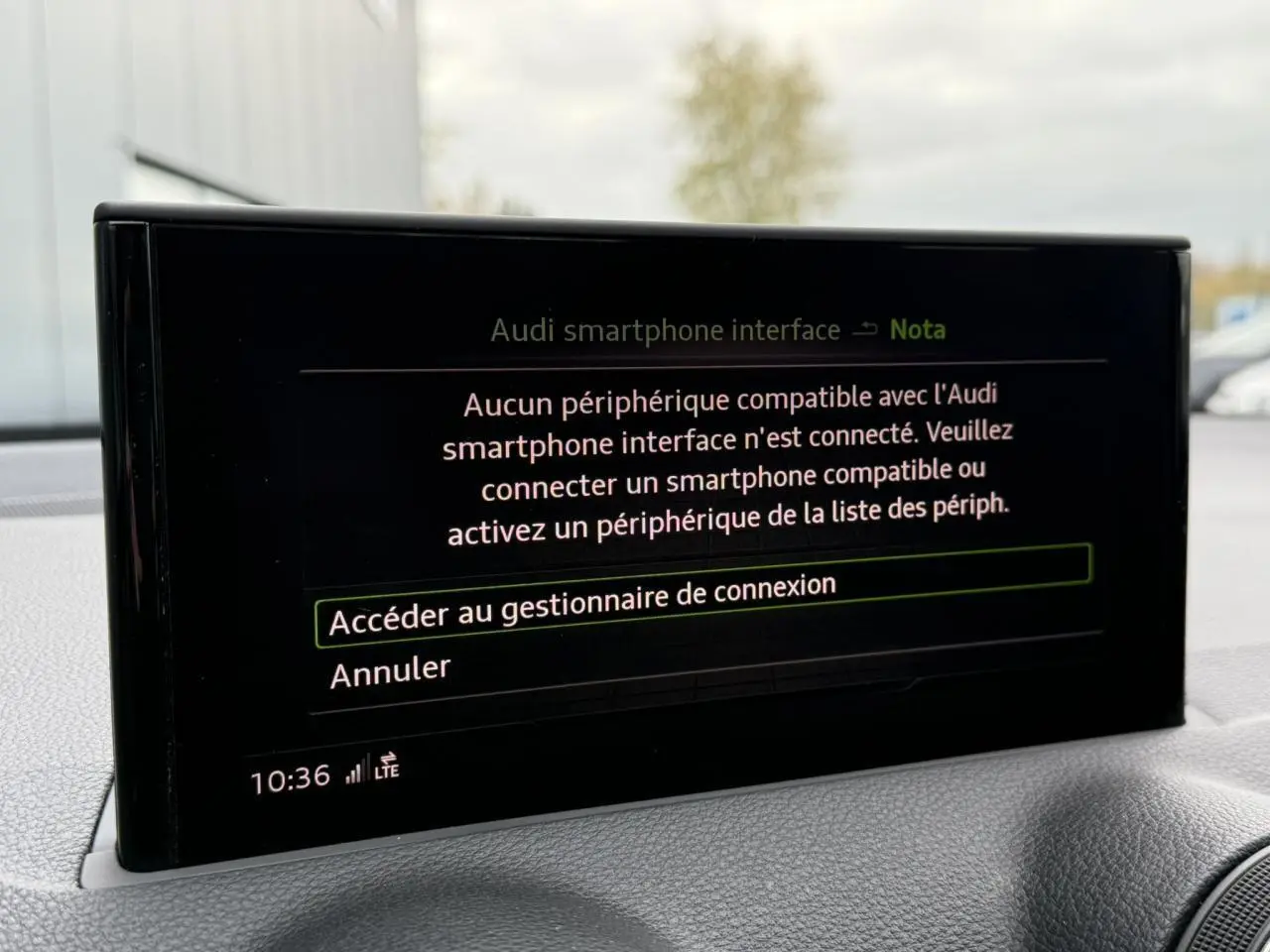 Écran central intérieur de l'Audi Q2 S line 2023 affichant le menu de connexion smartphone, tableau de bord gris.