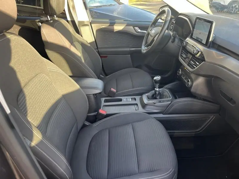 Vue intérieure côté conducteur du Ford Kuga 2.0 EcoBlue 150ch mHEV Titanium 2021, sièges tissu noir et boîte manuelle.