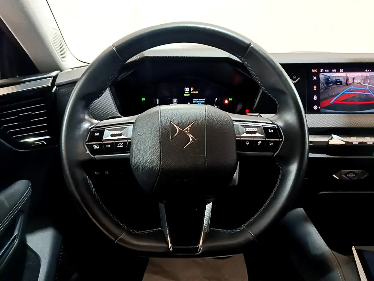 Vue frontale du volant cuir DS de la DS4 E-TENSE 225 TROCADERO 2023 avec tableau de bord numérique et écran tactile de recul.