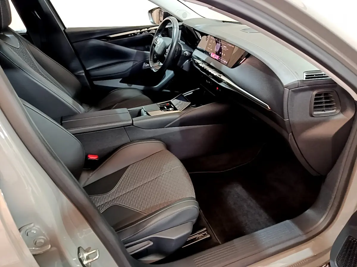 Intérieur côté conducteur du DS4 E-TENSE 2023, sièges noirs, tableau de bord numérique et volant cuir multifonctions.