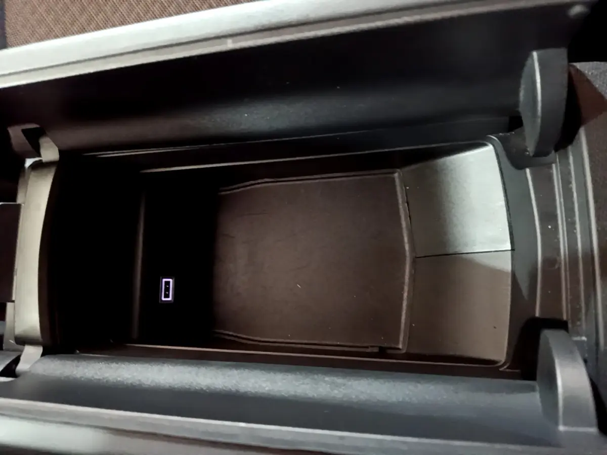 Vue rapprochée de la console centrale ouverte du DS4 E-TENSE 225 TROCADERO avec port USB visible, intérieur noir.