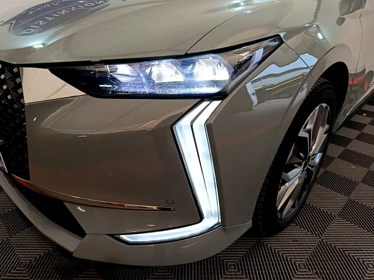 Gros plan sur l'avant droit gris foncé du DS4 E-TENSE 225 avec ses phares LED et feux diurnes en forme de flèche.