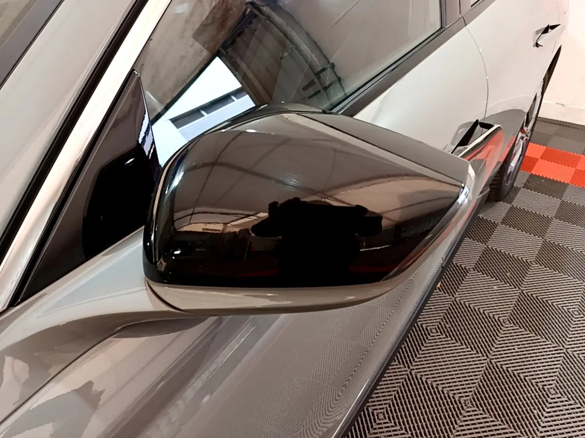 Rétroviseur noir brillant côté gauche du DS4 E-TENSE gris foncé, vue rapprochée sur la portière avant.
