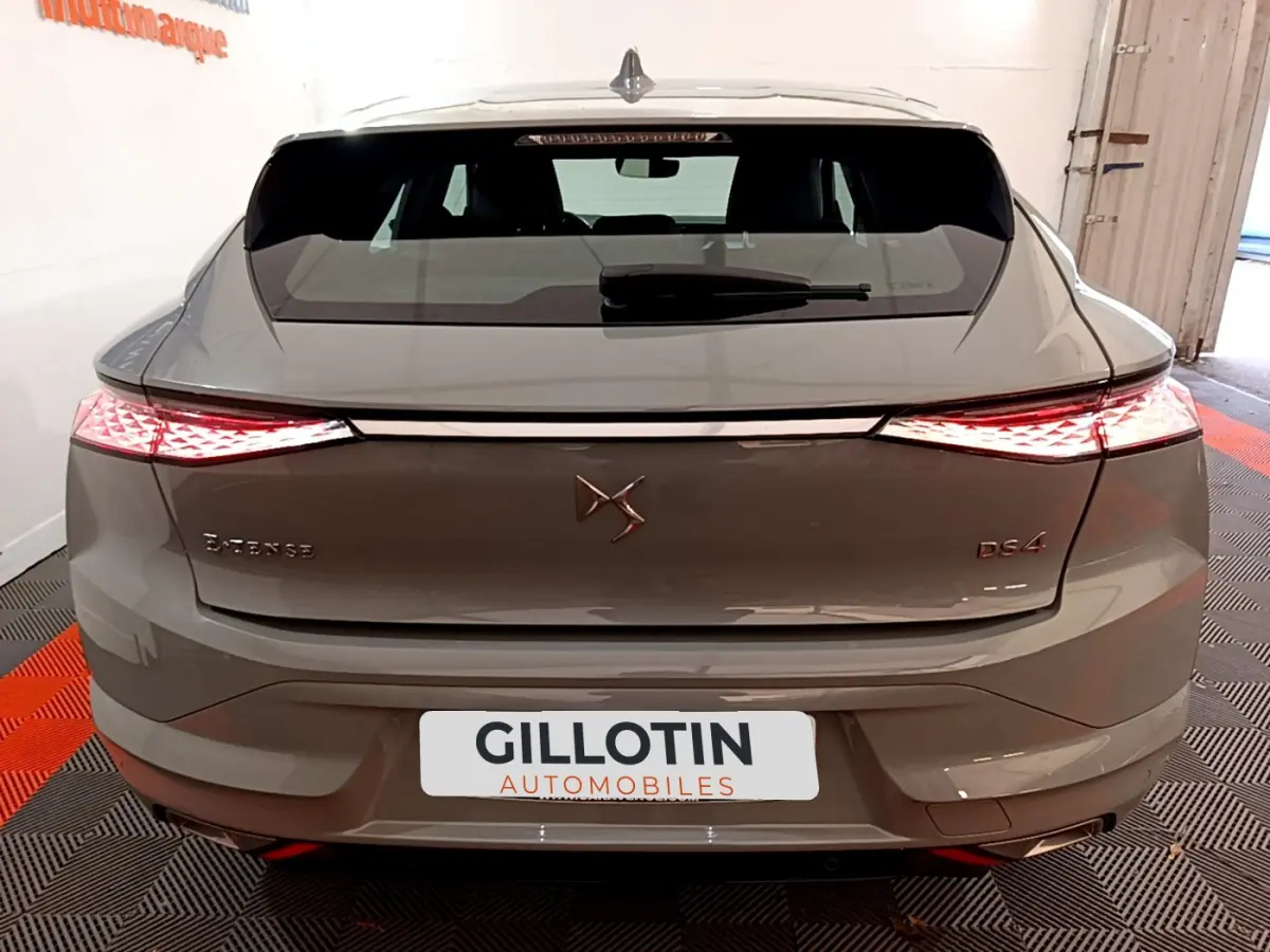 Vue arrière d'une DS4 E-TENSE 225 TROCADERO hybride rechargeable gris foncé avec feux LED allumés en intérieur