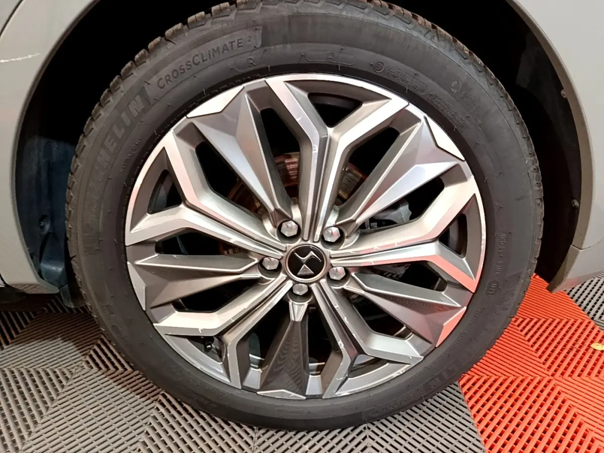 Gros plan sur la jante alliage au design géométrique du côté avant droit d'un DS4 E-TENSE gris foncé 2023