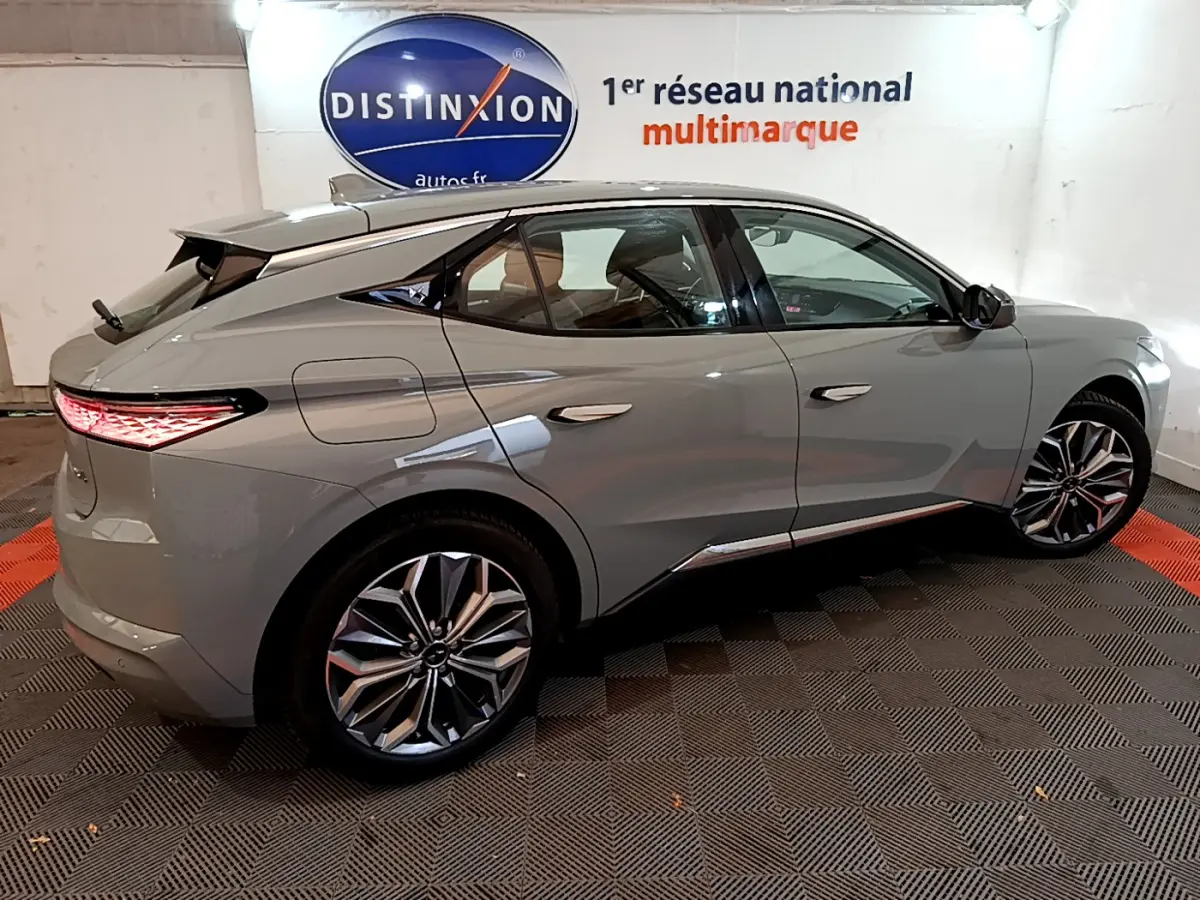 Vue latérale droite d'une DS4 E-TENSE 225 TROCADERO gris foncé avec jantes alliage et feux arrière LED allumés.