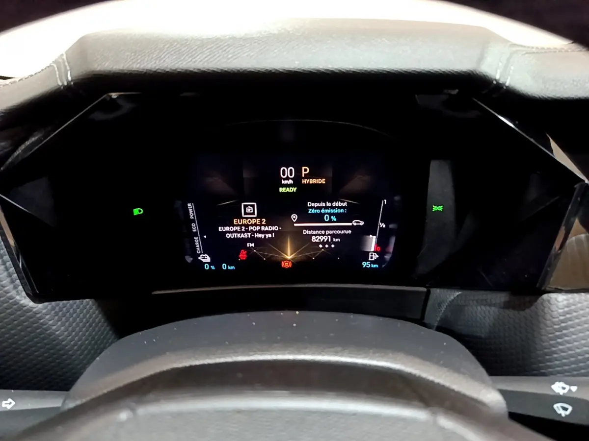 Vue rapprochée du tableau de bord numérique du DS4 E-TENSE 225 TROCADERO, affichage hybride et radio en cours.